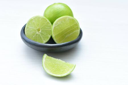 (Citrus - latifolia, the Persian lemon, whole and in pieces tahiti lemons accompanied by salt with an intense greenの写真素材