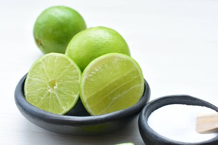 (Citrus - latifolia, the Persian lemon, whole and in pieces tahiti lemons accompanied by salt with an intense greenの写真素材