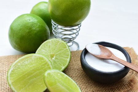 (Citrus - latifolia, the Persian lemon, whole and in pieces tahiti lemons accompanied by salt with an intense greenの写真素材