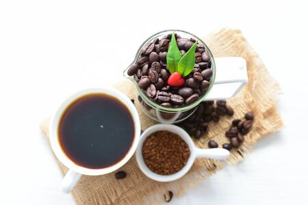 Coffee beans displayed in containers and watered, accompanied by espresso on flat backgroundの写真素材
