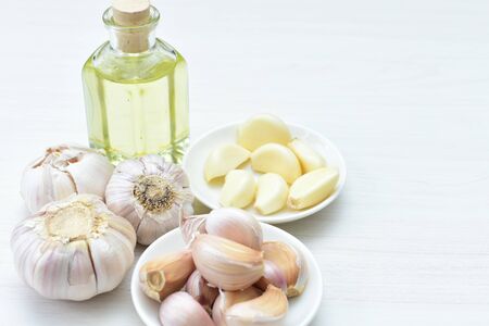 Allium sativum - Whole and minced garlic accompanied by garlic oil on a flat and decorated backgroundの写真素材