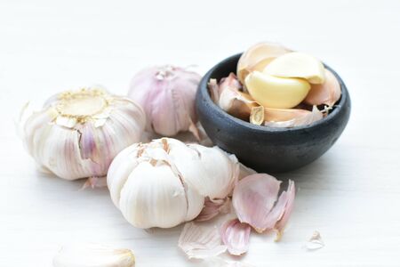 Allium sativum - Whole garlic, minced and shelled displayed in containers on light backgroundsの写真素材