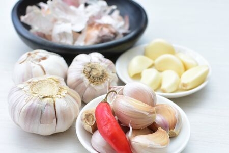 Allium sativum - Whole garlic, minced and shelled displayed in containers on light backgroundsの写真素材