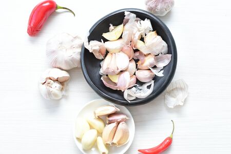 Allium sativum - Whole garlic, minced and shelled displayed in containers on light backgroundsの写真素材