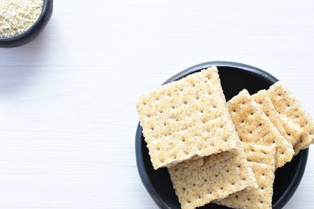 Whole and sliced healthy soda crackers with sesame on flat bottomsの写真素材