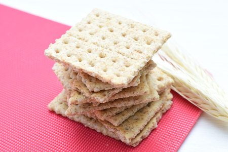 Whole and sliced healthy soda crackers with sesame on flat bottoms
