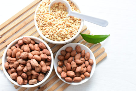 Arachis hypogaea - Peanut variety in seed, whole and crushed peanuts displayed in containers on...