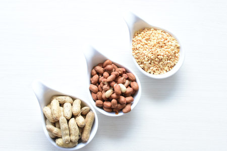 Arachis hypogaea - Peanut variety in seed, whole and crushed peanuts displayed in containers on...
