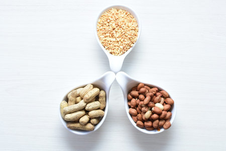 Arachis hypogaea - Peanut variety in seed, whole and crushed peanuts displayed in containers on...