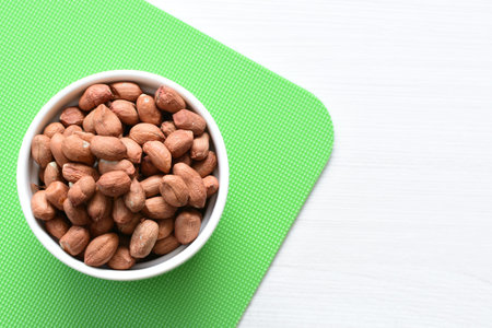 Arachis hypogaea - whole raw peanut displayed in containers accompanied by groundnut in seed and...