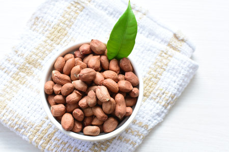 Arachis hypogaea - whole raw peanut displayed in containers accompanied by groundnut in seed and...