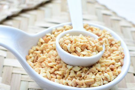 Arachis hypogaea - whole and chopped raw peanuts displayed in flat-bottomed containers