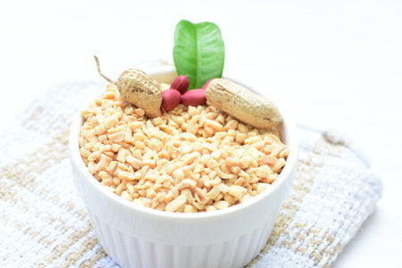 Arachis hypogaea - whole and chopped raw peanuts displayed in flat-bottomed containers