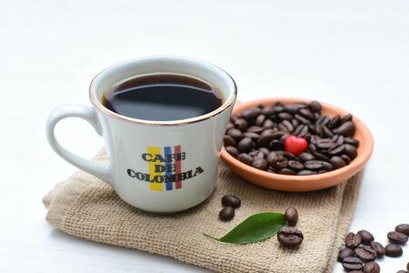 Traditional cup of coffee, accompanied by coffee beans on white backgroundの写真素材