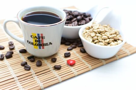 Traditional cup of coffee, accompanied by coffee beans on white backgroundの写真素材