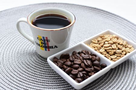 Traditional cup of coffee, accompanied by coffee beans on white backgroundの写真素材