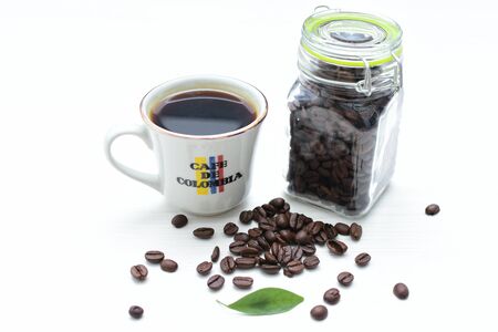 Traditional cup of coffee, accompanied by coffee beans on white backgroundの写真素材