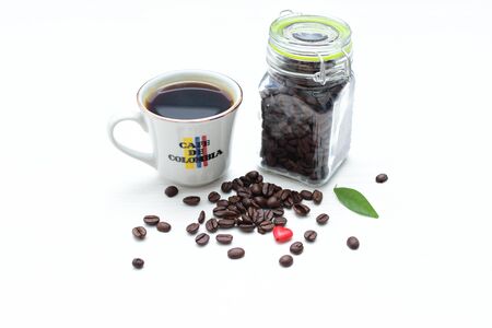 Traditional cup of coffee, accompanied by coffee beans on white backgroundの写真素材