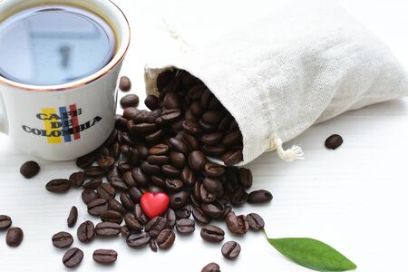 Traditional cup of coffee, accompanied by coffee beans on white backgroundの写真素材