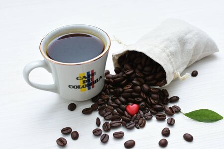 Traditional cup of coffee, accompanied by coffee beans on white backgroundの写真素材