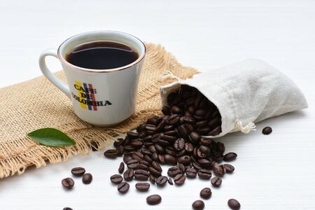 Traditional cup of coffee, accompanied by coffee beans on white backgroundの写真素材