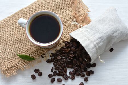 Traditional cup of coffee, accompanied by coffee beans on white backgroundの写真素材
