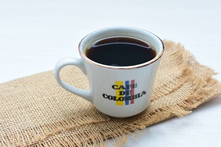 Traditional cup of coffee, accompanied by coffee beans on white backgroundの写真素材