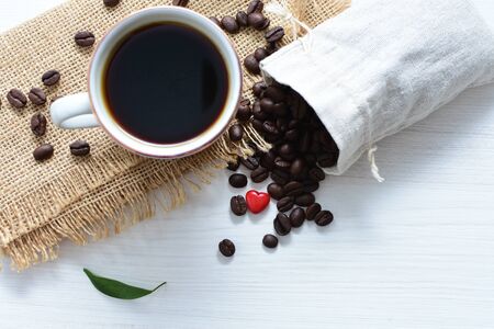 Traditional cup of coffee, accompanied by coffee beans on white backgroundの写真素材