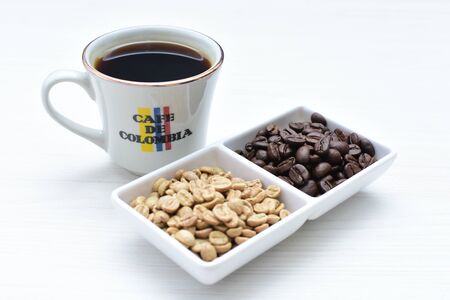 Traditional cup of coffee, accompanied by coffee beans on white backgroundの写真素材