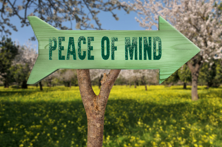 trunk and wooden sign indicating to peace of mindの写真素材