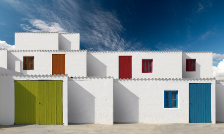 facades of houses with white wall and painted wooden doorsの写真素材