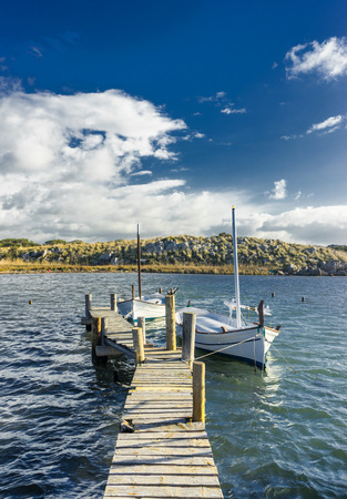 llaut on wooden dock in menorcaの写真素材