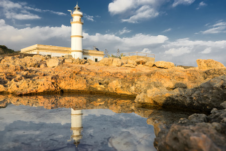 lighthouse on the coast  reflected in waterの写真素材