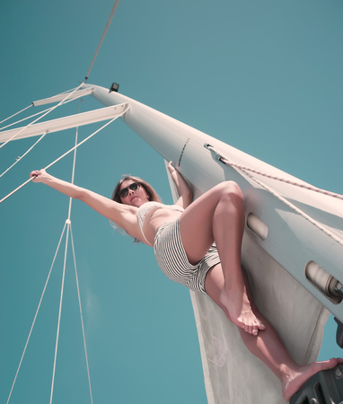 Woman in bikini on a sailboat sunbathingの写真素材