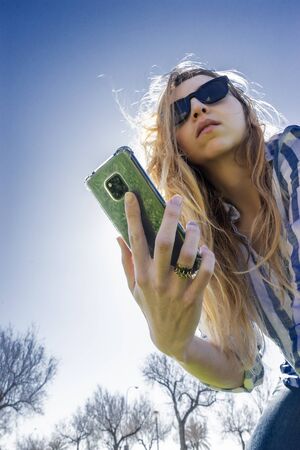 woman using cell phone, sunny dayの写真素材