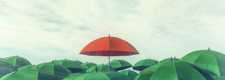 3d illustration of a red umbrella standing out among other greensの写真素材