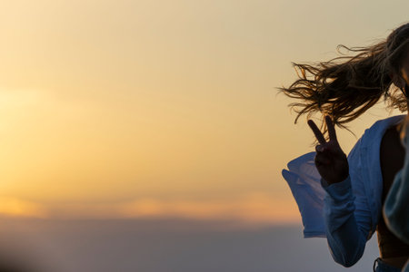 woman making the victory sign with her hair in the air
