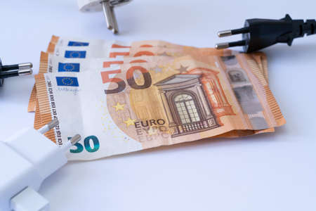 Electric sockets with euro banknotes on white background.の写真素材