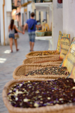 Seville, Spain, July 11 2021: View of a basket with spices while a couple walking in the Santa Cruz neighborhood.のeditorial素材