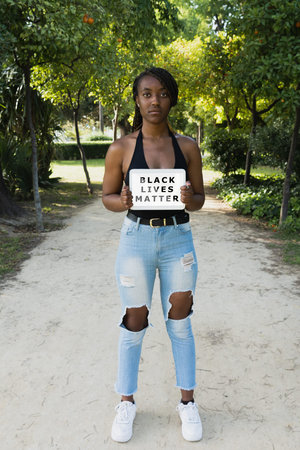 Black lives matters, protest. Young African woman with an angry gesture. Vertical shot.