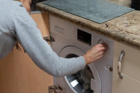 Woman washing clothes. Concept of rising energy prices. Concept of electricity consumptionの写真素材