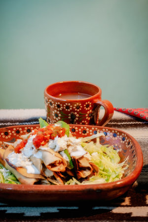 A Mexican flautas with lettuce, avocado, cream, sauce and fresh waterの写真素材
