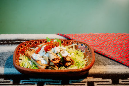 A Mexican flautas with lettuce, avocado, cream, sauce and fresh waterの写真素材
