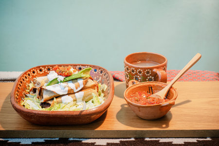 A Mexican flautas with lettuce, avocado, cream, sauce and fresh waterの写真素材
