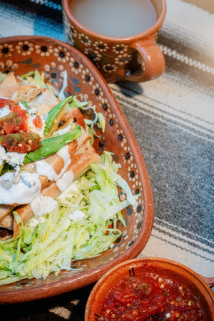 A Mexican flautas with lettuce, avocado, cream, sauce and fresh waterの写真素材
