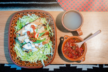 A Mexican flautas with lettuce, avocado, cream, sauce and fresh waterの写真素材
