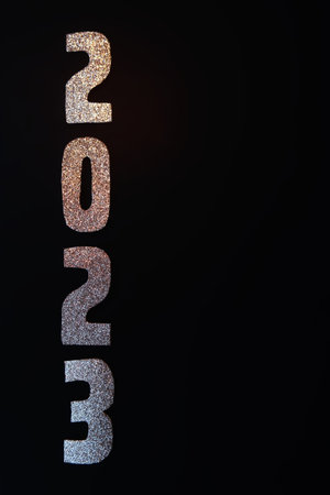 A Happy New Year 2023. Golden numbers on a black background with glitter