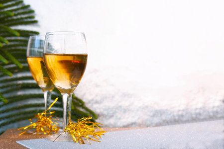 A Beautiful champagne glasses with Christmas decorations and shiny silver backgroundの写真素材
