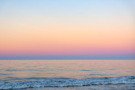 A beautiful sunny and pink sunrise on the beachの写真素材