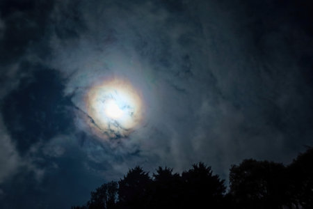 A Clouds pass in front of the moon in a night sky.の写真素材